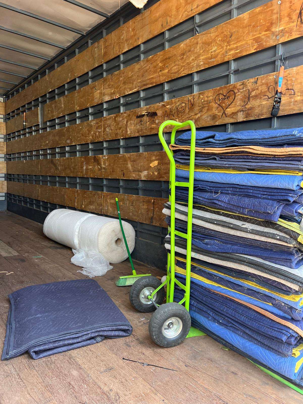 Stacked furniture blankets and trolley in an RB Removals truck
