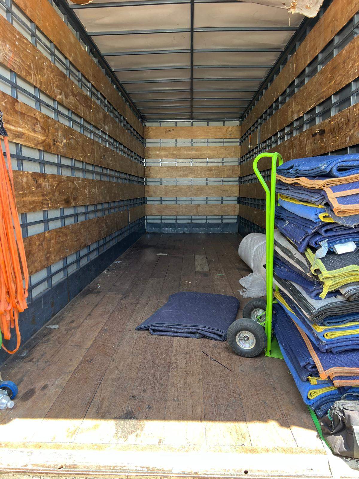 Inside an RB Removals truck with furniture blankets and a trolley