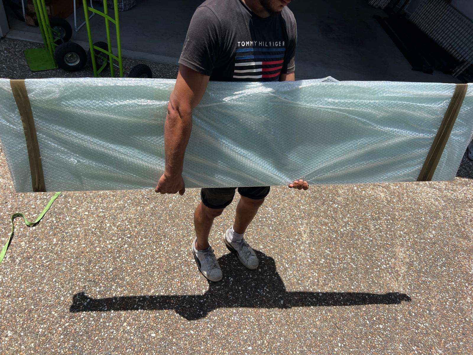 Removalist carrying a wrapped glass panel